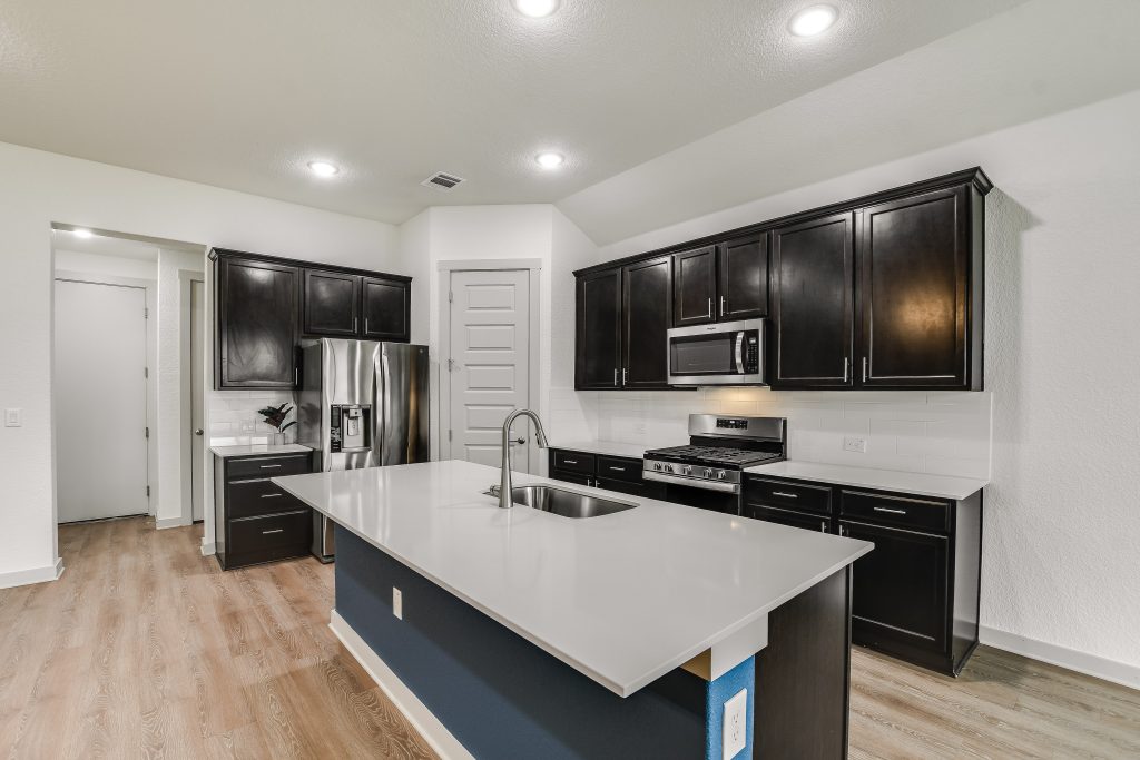 Spacious island with bar top for extra seating. Hall that leads to garage has a large pantry, separate laundry room and a coat closet. Tons of storage in this home!