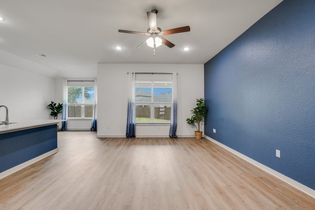 Large open concept living area with windows overlooking the covered patio and spacious back yard.