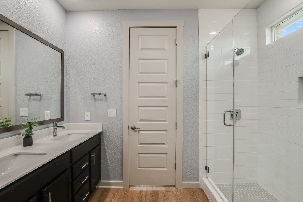 Main bathroom features a walk-in glass enclosed shower, double sinks, linen closet, separate water closet and a huge walk-in clothes closet.
